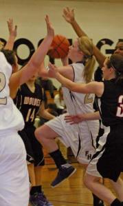 Friday Harbor senior Jean Melborne fends off a  crowd of Coupeville defenders to drop in a 2-point runner in the lane in the Wolverines 34-23 victory at home