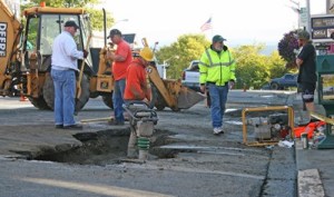 Town workers attend to a sinkhole on Spring Street in the wake of a break in the town water-main on Labor Weekend