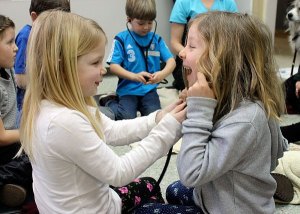 Allie Green and Lyla Ovenell listen to each others heartbeats