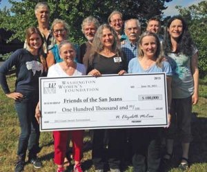 Staff and board members of Friends of the San Juans display a $100