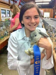 Friday Harbor's Jersie Angel poses for a photo with her state fair blue-ribbon winning bunny.