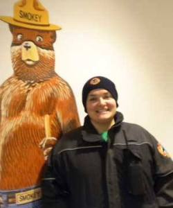 Volunteer firefighter Micelle Stringer poses for a photographer alongside her firefighting hero