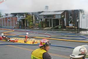 Smoke billows from the wreckage and the roof of Downriggers after a fire gutted the building's interior in the early morning hours of Saturday
