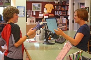 Max Kessler checks out a book from San Juan Island with help of the library’s Adrienne Bourne.
