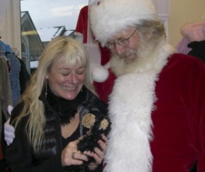 Lorie Narum of Second Act admires the teddy bear she received during Santa's early pass through the island. He's expected to visit downtown Friday Harbor today.