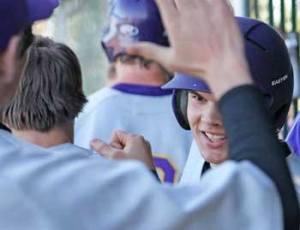 Sophomore Kai Herko gets a 'high-five' from teammates after scoring a run in a home game a year ago
