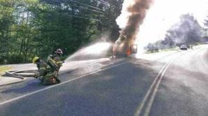 Firefighters douse water on a car in flames after the Toyota burst into flames near the intersection of Rouleau and Roche Harbor roads Monday morning.