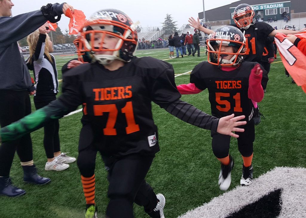 Little league football teams win championship trophies