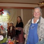 Staff photo/Hayley Day                                Layne Sundberg of Quail Croft goat cheese and Sandy May and Carol Liu of Market Garden Co-op man their booths at Brickworks Old-Fashioned Christmas Market.