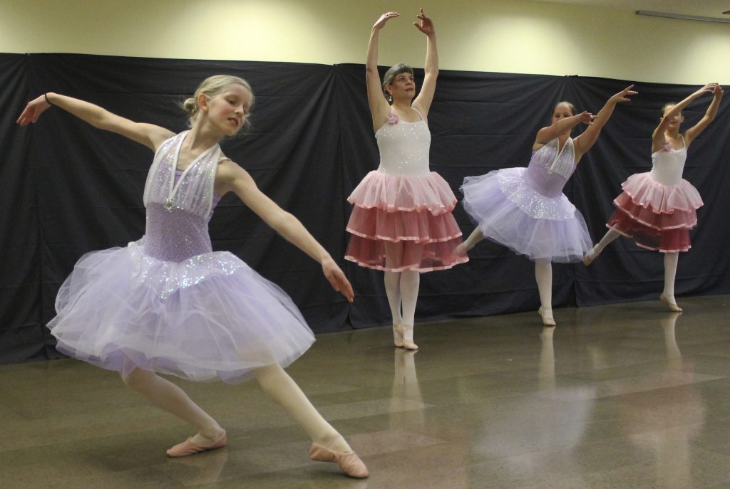 Staff photo/ Hayley Day                                Anabelle Mountford dances the Waltz of the Flowers, as Regina Kammer and Eleanore Rollins pose behind.
