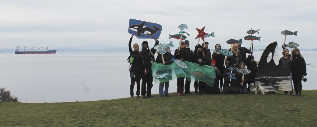Staff photo/Hayley Day                                San Juan Islanders protest against the increase of vessel traffic, just as a ship sails by.