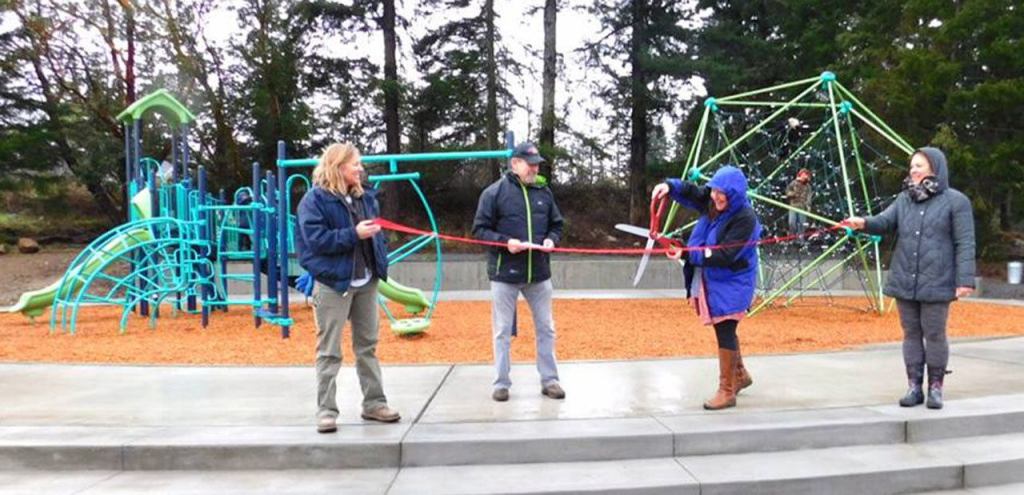 Contributed photo/Island Rec                                Director of Island Rec Maddie Ovenell cuts the ribbon at the opening of the playground in John O. Linde Community Park.