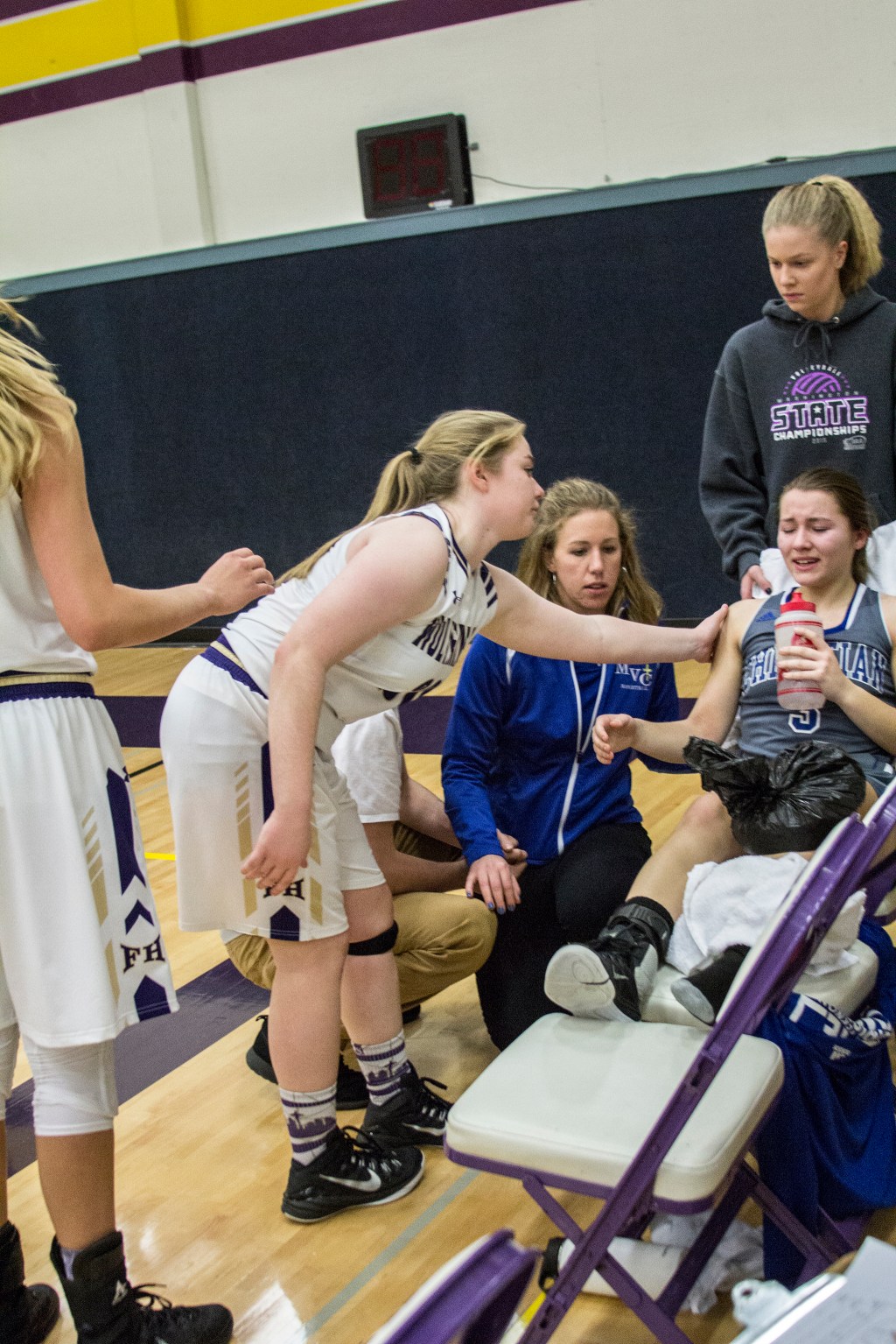 Staff photo/Greg Sellentin                                Senior Hannah Hopkins, and the other Wolverine players, offer support to a Mount Vernon player who was injured in the last-minute of play.