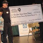 Staff photo/Hayley Day                                San Juan Island Public Schools Foundation representatives award San Juan Island School District superintendent a check for $117,940 for the district near the end of the game.