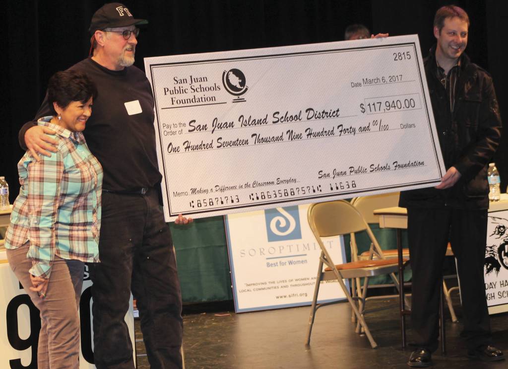 Staff photo/Hayley Day                                San Juan Island Public Schools Foundation representatives award San Juan Island School District superintendent a check for $117,940 for the district near the end of the game.
