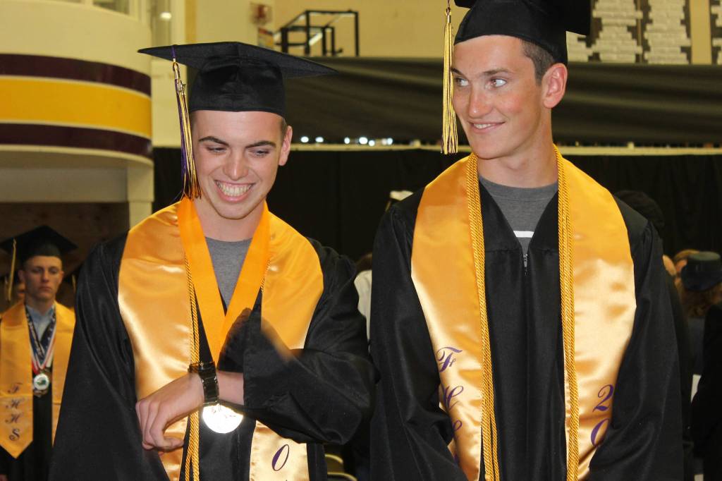 Staff photo/Heather Spaulding                                Graduates Corbin Williams and Eli Cooper West walk toward the podium.