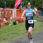 Staff photo. Runner waves as heads out on last leg of the race