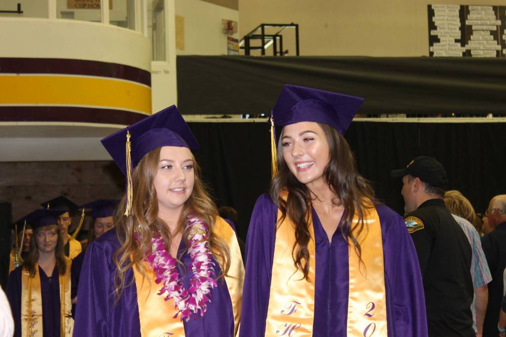 Staff photo/Heather Spaulding                                Graduates in caps and gowns walk toward the podium.