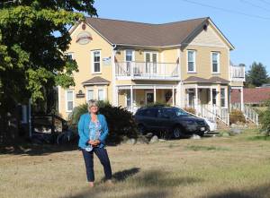 Staff photo/Hayley Day                                Lynn Danaher stands in front of an Argyle Suites building she owns. Her plan is to build similar structures on the available lots, she&rsquo;s standing on, if her bid goes through.