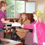 Staff photo. Lily Compton gives Ingrid Gabriel a copy of Erie NY microbead laws.