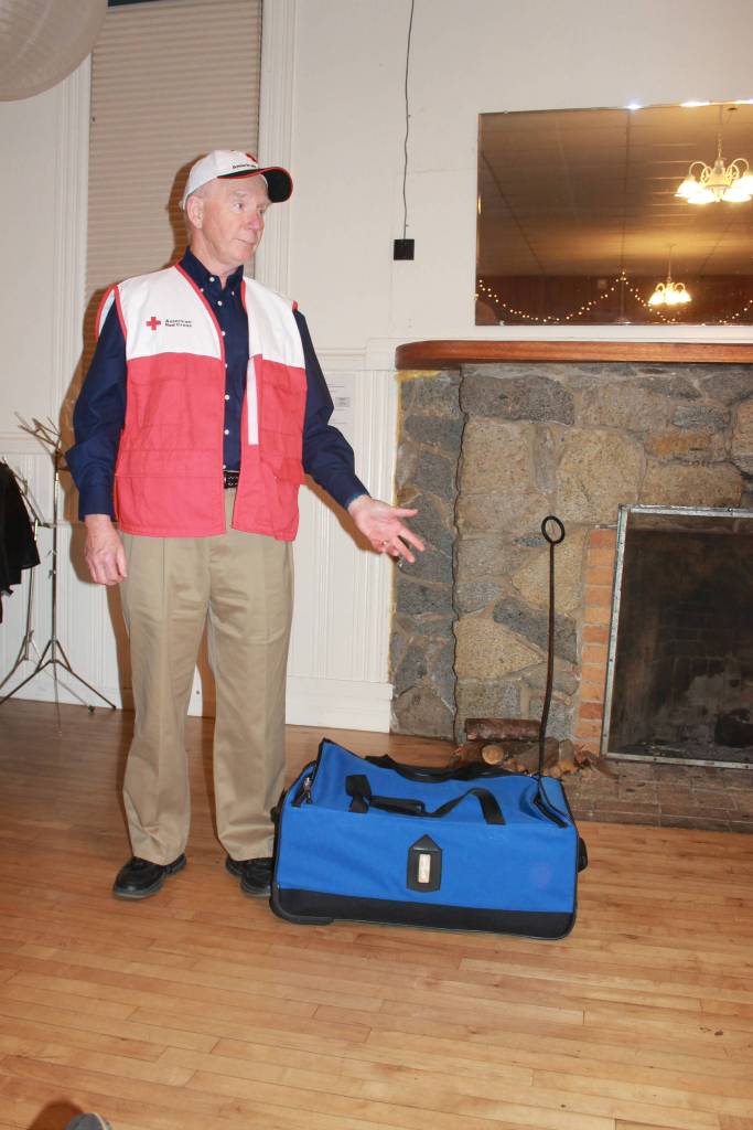 Staff photo/Heather Spaulding.                                Red Cross volunteer Bill Severson demonstrates a to go bag.