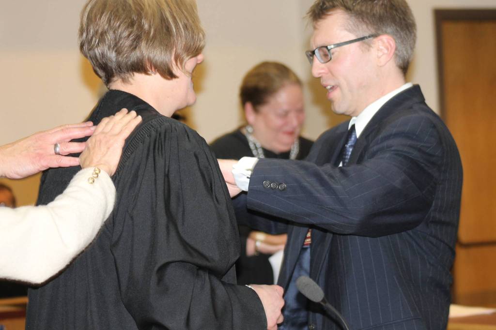 Staff photo/Heather Spaulding Kyle Loring zips his wifes robe, before the countys newly appointed San Juan Superior Court Judge Katie Loring takes the bench.