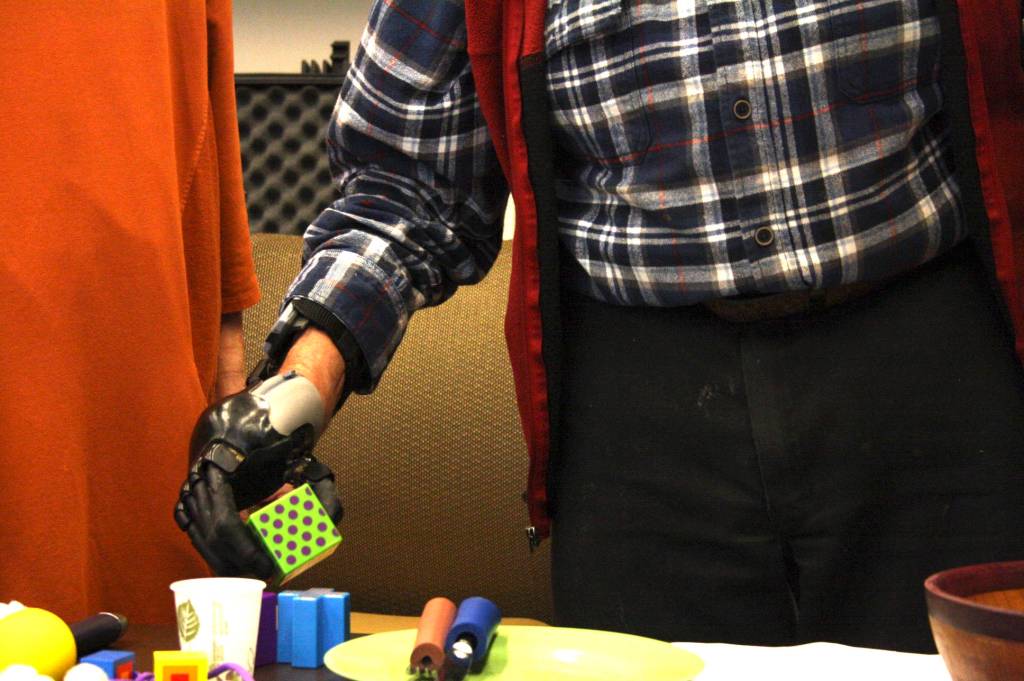 Staff photo/Hayley Day                                Lyle Mann picks up a block with his bionic hand at Peace Island Medical Center on Dec. 28.