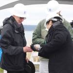 Staff photo/Hayley Day                                Keizo Takeo from the company that made the cable, Sumitomo Electric, pours sake for guests to celebrate the cable installation.
