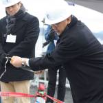Staff photo/Hayley Day                                Kazuhira Harada from the company that made the cable, Sumitomo Electric, pours sake on the cable to celebrate its installation.