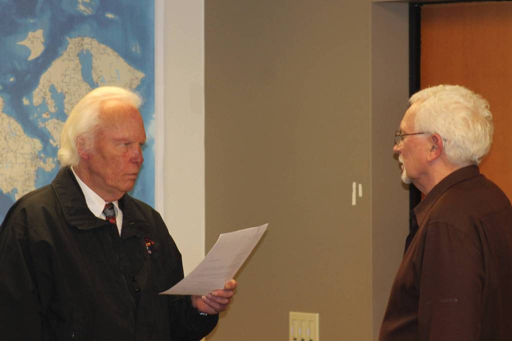 Staff photo/Heather Spaulding Dr. Warren Appleton is sworn in by commissioner Michael Edwards.