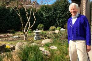 Contributed photo/PIMC                                Carolyn Haugen stands at the garden entrance at PIMC.