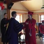 Staff photo/Heather Spaulding. Lauren Ford-Johnson receives degree from college president Thomas Keegan.