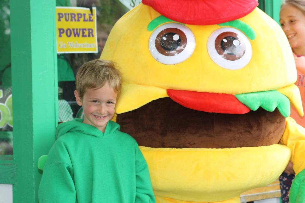 Staff photo/Hayley Day                                A child poses with the Vics burger mascot outside the 60th-anniversary party.