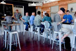 Staff photo/Tate Thomson                                Patrons enjoy the new bar at its soft opening on July 26.