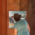Staff photo/Hayley Day                                A visitor looks at artwork, by Dan Attoe, displayed at English Camp.