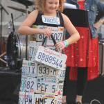 Staff photo/Heather Spaulding Sisters show off their evergreen creation.                                Staff photo/Heather Spaulding Model shows off dress and handbag created from old license plates.