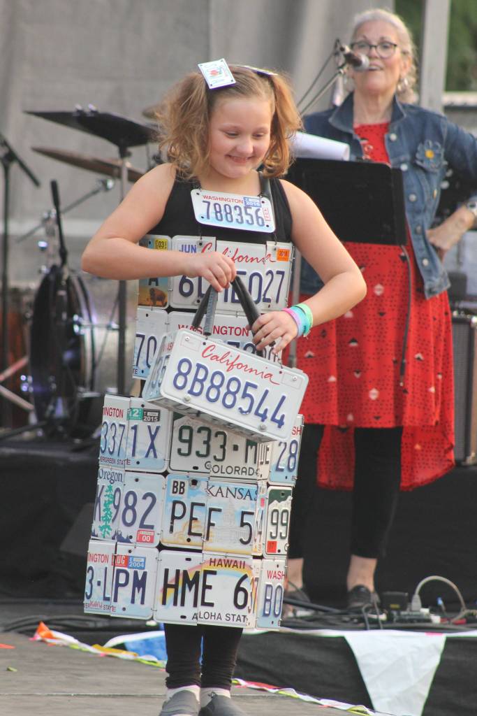 Staff photo/Heather Spaulding Sisters show off their evergreen creation.                                Staff photo/Heather Spaulding Model shows off dress and handbag created from old license plates.