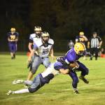 Contributed photo / John K. Stimpson                                Wolverine Kyson Jackson, 22, slows down a Lions ball carrier with additional help coming from Gavin Mason, 53.