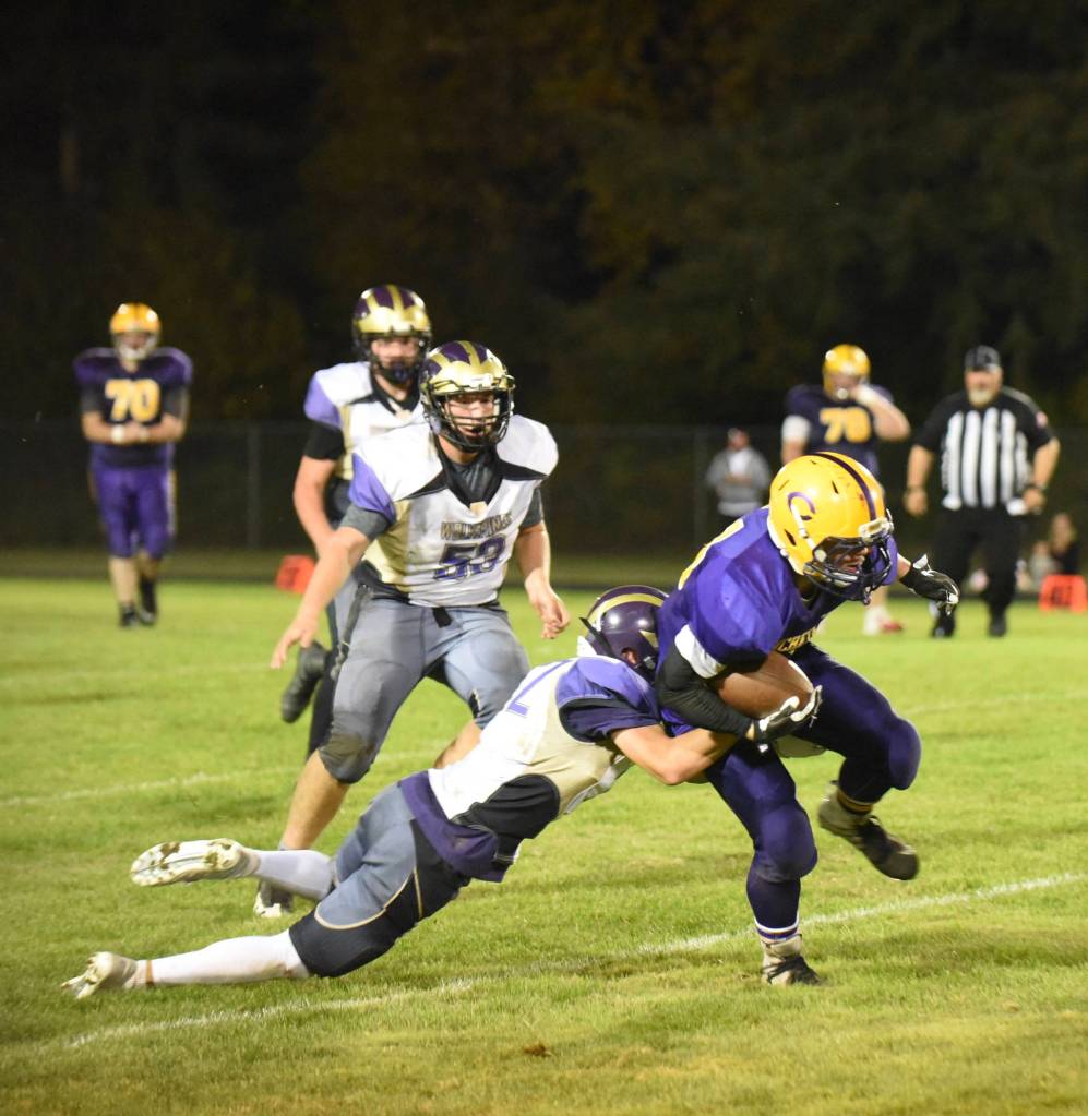 Contributed photo / John K. Stimpson                                Wolverine Kyson Jackson, 22, slows down a Lions ball carrier with additional help coming from Gavin Mason, 53.