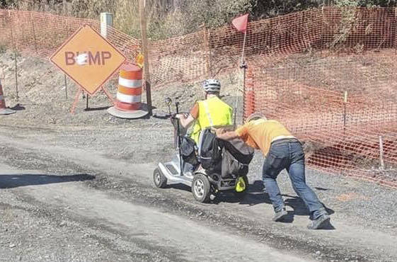 Contributed photo                                A construction worker pushes Aaron DErrico up Tucker Avenue when his previous scooter fails.