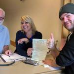 Contributed photo/San Juan County                                Ryan Palmateer receives his quick title from San Juan County Auditor employees Oren Combs and Kira Sable.
