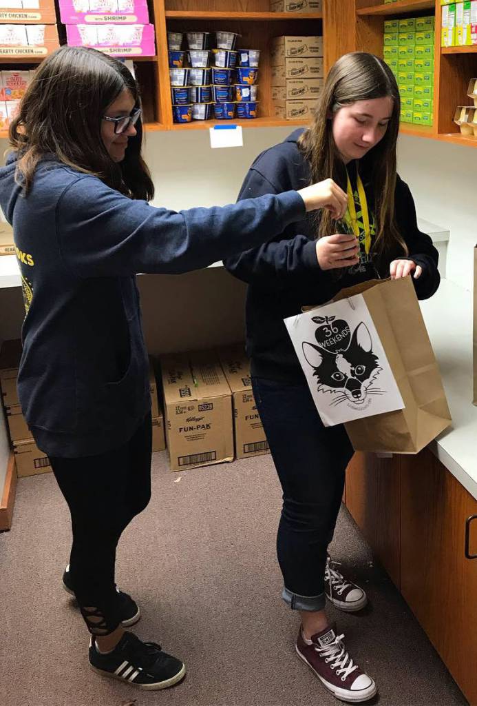 Contributed photo                                Emily Cain created a new service club at the school. Here the club is helping out another organization that packs bags of food for elementary school students over the weekend.