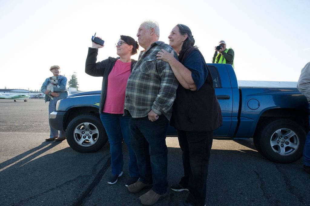 John Norman, his wife, Heather (right), and daughter Amber Nelson watch as his replica of the Spirit of St. Louis takes off on its first flight from Arlington Municipal Airport on July 28. (Andy Bronson / The Herald)