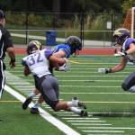 Wolverine Kaden Ritchie (32) drives the Viking ball carrier out of bounds. <em>(John Simpson/Contributed photo)</em>