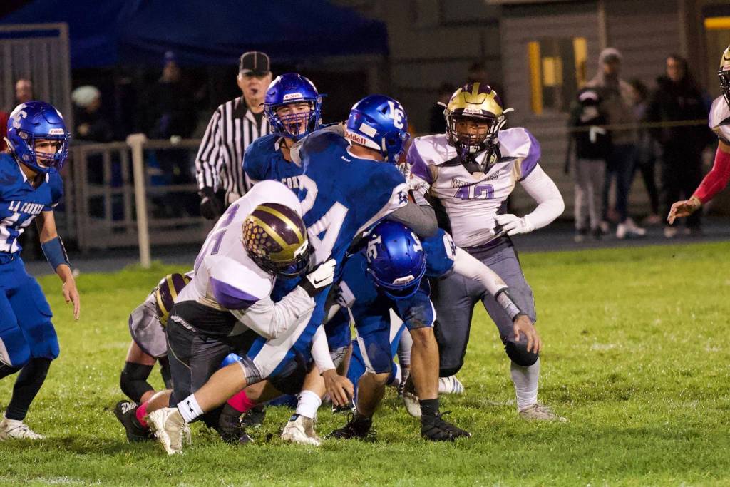 Ty Vague, No. 65, brings down the Braves running back for a yardage loss. (John Stimpson/Contributed photo)