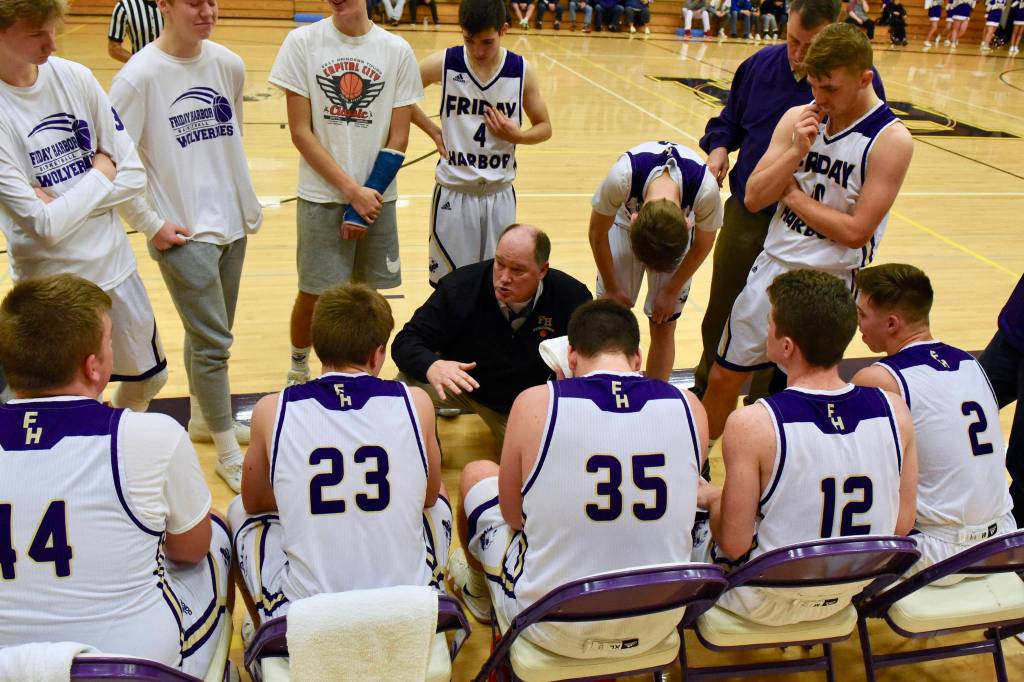 Head Coach Rod Turnbull talks strategy to the starting five players. (John Stimpson contributed photo.)