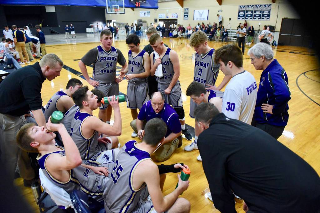 Head Coach Rod Turnbull discusses strategy while players refresh themselves for the next overtime minutes. (John Stimpson/contributed photo)