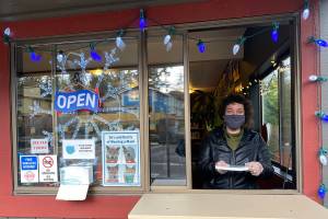 Assistant Director Rowan Buckerton working at the librarys curbside window. (Contributed photo)
