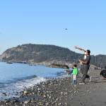 Raghu Maddirala of Bellevue and son Arjun, 3, throw rocks at West Beach in Deception Pass State Park last Saturday. The park would be used as a Navy training site along with others on Whidbey under a new five-year proposal. Photo by Emily Gilbert/Whidbey News-Times