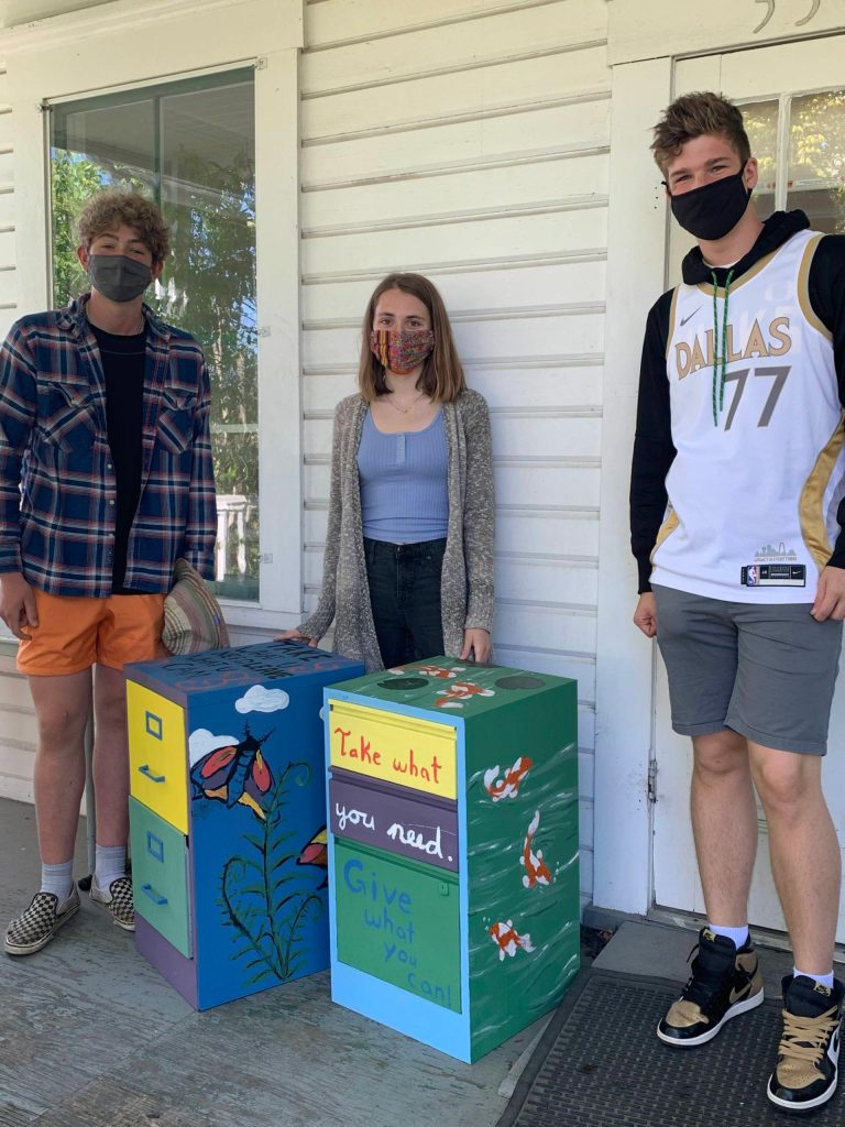 Students standing next to food distribution cabinets. From left to right: Francis Black, Linnea Morris, and Julian Rich. (Contributed photo)